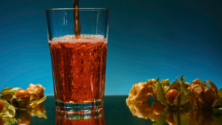 Beautiful pouring of drink into glass with ingredients. Stock clip. Refreshing drink is poured into transparent glass. Beautiful drink with aesthetics for advertisingの写真素材