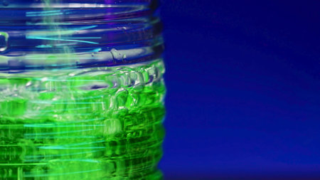 Close-up of green drink being poured into glass. Stock clip. Green drink with bubbles in bar is poured into transparent glass. Alcoholic bar drink on isolated background. Nightlife and clubsの写真素材