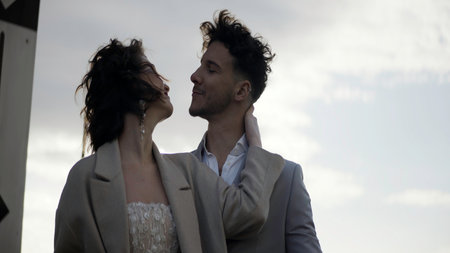 A young couple in love. Action. Graceful flirting poses of a man and a woman posing for a photographer on the street in the wind.の写真素材