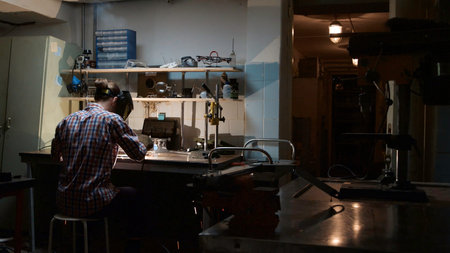 Back view of professional welder man with torch and protective mask welding steel with spark in...