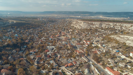 Town surrounded by the rocky hills. Shot. Aerial view of beautiful urban landscape near the mountainsの写真素材