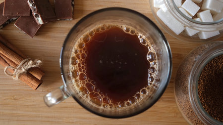 Black coffee in a cup on the table in a composition with chocolate and cinnamon. Concept. Close up...