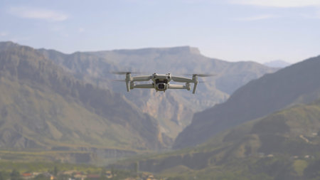 Quadcopter flies on background of mountains. Action. View of quadrocopter flying in air on...