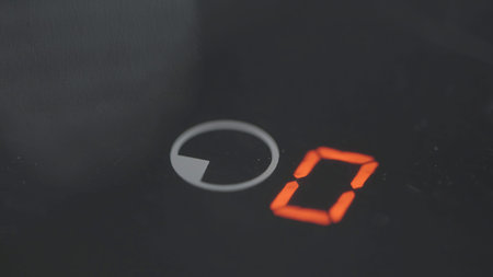 Close-up of pressing timer button on electric stove. Action. Finger presses one touch button on...
