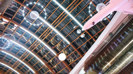 View from the bottom on the white airplane model hanging against the beautiful ceiling with illumination in the shape of the outer space objects. Concept. Museum of scienceの写真素材