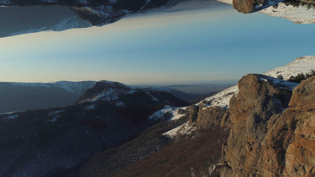 Aerial of snowy inaccessible and very high peaks of the mountains in the northeastern part of Italy on a winter sunny day. Shot. Surreal upside down mirrored world.の写真素材