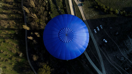Aerial view of a blue balloon in the sky over the countryside area, France. Shot. Flying above...