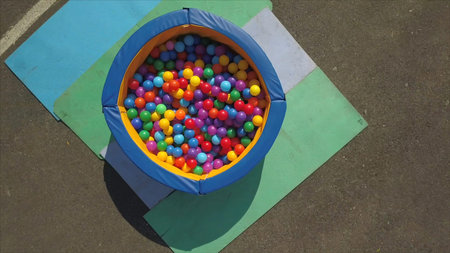 Aerial view of recreation center with green roof, large site and small pool with colorful balls...