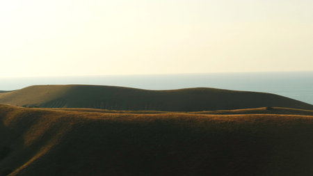 Aerial view of high hills and blue sea on the background against the evening sky in summer. Shot. Amazing colorful landscapeの写真素材