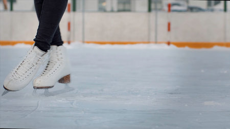 Professional female ice figure skater practicing spinning on outdoor skating rink. Video. Woman ice dancing surrounded by residential high rise houses.の写真素材