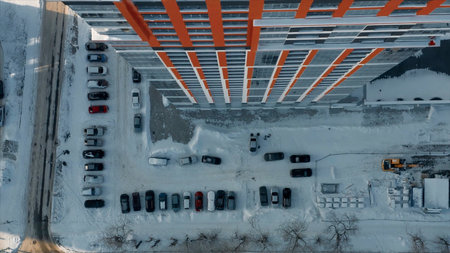 Aerial top view of the typical residential area with many cars parked by the high rise building. Video. Details of a residential house and a snow covered road, big city life in winter.の写真素材