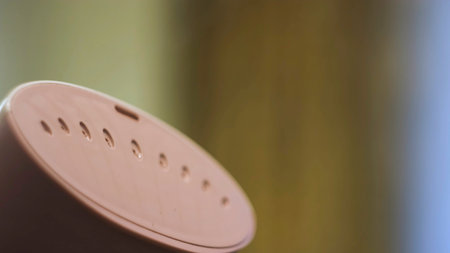 Close up of hand steamer for ironing clothes. Concept. Small pink electronic device for ironing with water steam on blurred background.の写真素材