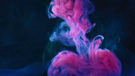 A beautiful mixture of acrylic inks in dark blue glittering water. Stock footage. Close up of pink ink stream forming amazing cloud while mixing with water.の写真素材