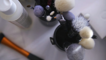 Close up of set of make up tools on white table background. Clip. Top view of many different brushes...