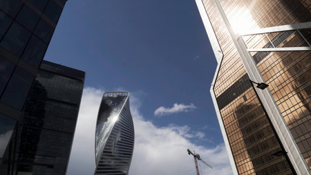 Low angle view of Moscow-City skyscrapers, Russia. Action. Bottom view of business district with high rise skyscrapers on blue sky background, modern office urban buildings in sunlight.の写真素材