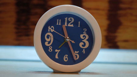 Close up of unusual alarm clock of blue color with white frame. Concept. Blue alarm clock with white...