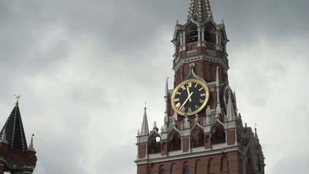 The Kremlin Clock or Chimes on Spasskaya Tower. Action. Red Square in Moscow, Russia, bottom view of Kremlin architecture on heavy cloudy sky background.の写真素材