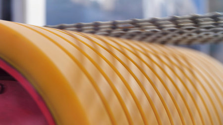 Close up of rotating yellow cylinder with abrasive blades for cutting concrete blocks. Media. Concept of new technologies in machinery and construction.の写真素材
