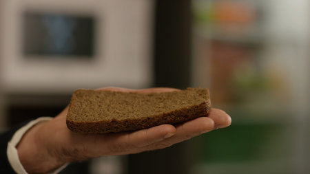 Healthy food concept. Stock footage. Close-up of mans hand in jacket and shirt holding a piece of...