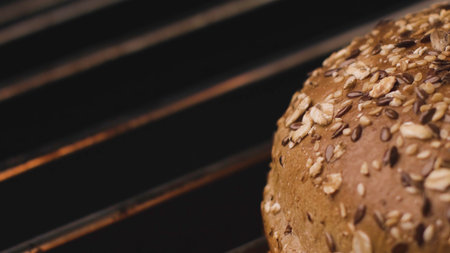 Close-up of hot Burger bun on grill. Stock footage. Delicious grain bread is grilled. Bun on grill for tasty Burger. Round loaf of bread to roast on fireの写真素材