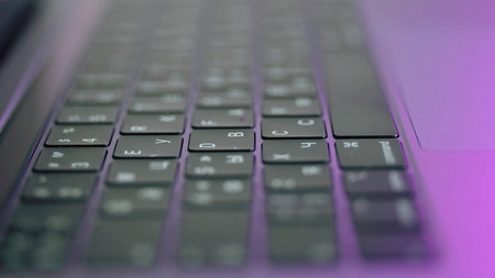 Side view of laptop or computer details, black keyboard with white symbols. Action. Extreme close up...