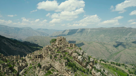 Ancient stone city on rock on background of mountains. Action. Amazing settlement of rock houses on top of mountain. Attraction of Dagestan - village of ghost in mountainsの写真素材