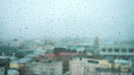 View of the city through the window and raindrops falling down on the glass. Stock footage. Autumn weatherの写真素材
