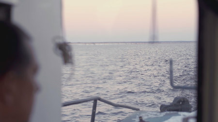 Experiencing a Serene and Beautiful View from a Vessel at Dusk Over the Calm Watersの写真素材