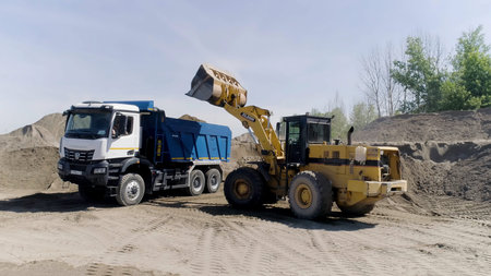 Aerial view of mining machinery. Scene. The bulldozer works at the quarry, loading excavator with...