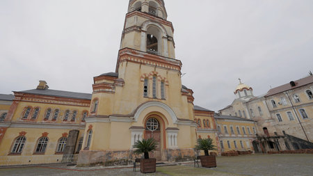 Bottom view of a church building with a tower. Action. Concept of architecture and religion, yellow...