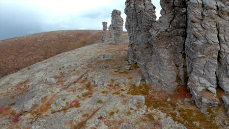 Aerial view of a peak of a mountain with stone rock formations. Clip. Beautiful hill top with stone...