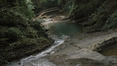 Natural wild background with a mountain river and a stream among rocks. Creative. Small pond in a gorge, summer tourism concept.の写真素材