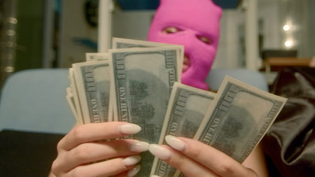 A girl in a pink mask who counts money. Footage. A young girl in a rubber mask and underwear,...