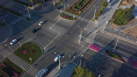 Top view of city intersection on summer day. Clip. Beautiful road intersection with morning traffic...