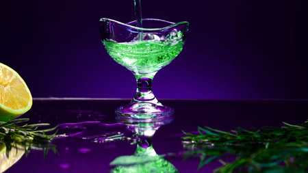 Close up of green drink in a glass on a dark blue background. Stock clip. Silhouette of a glass with...