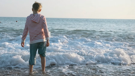 Boy on sea with big waves. Creative. Boy is resting on sea with waves in slow motion. Beautiful and fun vacation by seaの写真素材