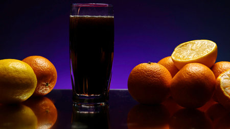 The concept of a bartender. Stock clip.Purple illuminated background with a large roomy glass in which soda is poured and the whole still life is decorated with light orangesの写真素材