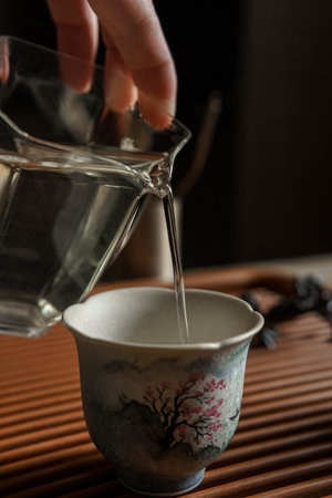 Elegant and Delicate Tea Pouring in a Beautiful Traditional Chinese Cup for Enjoymentの写真素材