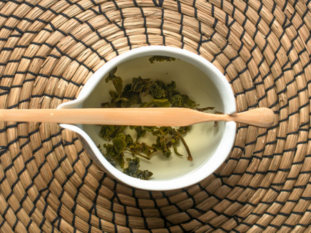 The Art of Tea Preparation Using Herbal Leaves in a Beautiful White Bowl to Enhance Flavorの写真素材