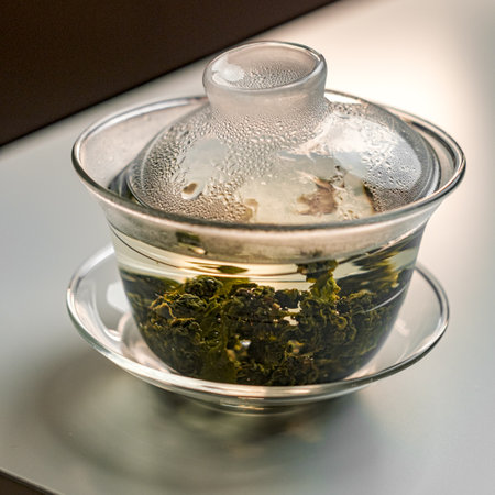 Enjoy the delightful steaming green tea infusion crafted in an elegant glass teapotの写真素材