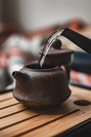 An elegant teapot gently pouring warm water to brew tea for a serene tea ceremonyの写真素材