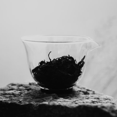 An Aesthetic Composition of Artistic Black and White Tea Leaves in a Glass Measuring Cupの写真素材