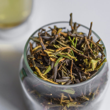 Beautiful and Delicate Green Tea Leaves Stored in a Glass Jar with Brewed Tea Inside
