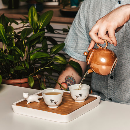 Enjoy the exquisite tea ceremony with an elegant teapot and beautiful cups on a decorative trayの写真素材