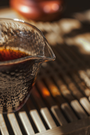 Experience Elegant Tea Brewing with a Beautiful Glass Teapot Bathed in Natural Lightの写真素材