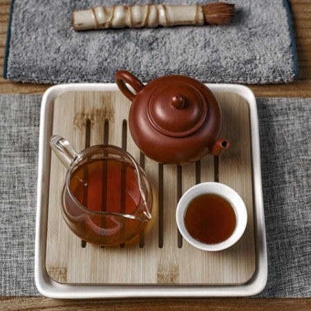A beautifully crafted Traditional Tea Set with Teapot and elegant Teacups on a Wooden Trayの写真素材