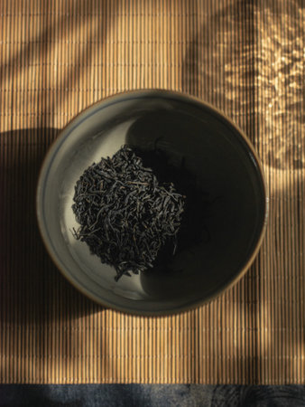 An Exquisite Bowl of Elegant Black Rice Set Against a Natural Textured Surface Backgroundの写真素材