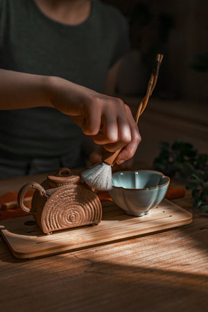 Engaging in the Artisanal Process of Tea Preparation in a Beautiful Natural Light Settingの写真素材