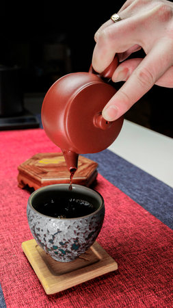 A Beautifully Designed Elegant Teapot Gracefully Pouring Tea into a Classic Tea Cupの写真素材