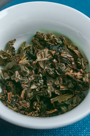 Dried Green Tea Leaves Placed in a Bowl, Ready for Brewing and Enjoying a Refreshing Drinkの写真素材